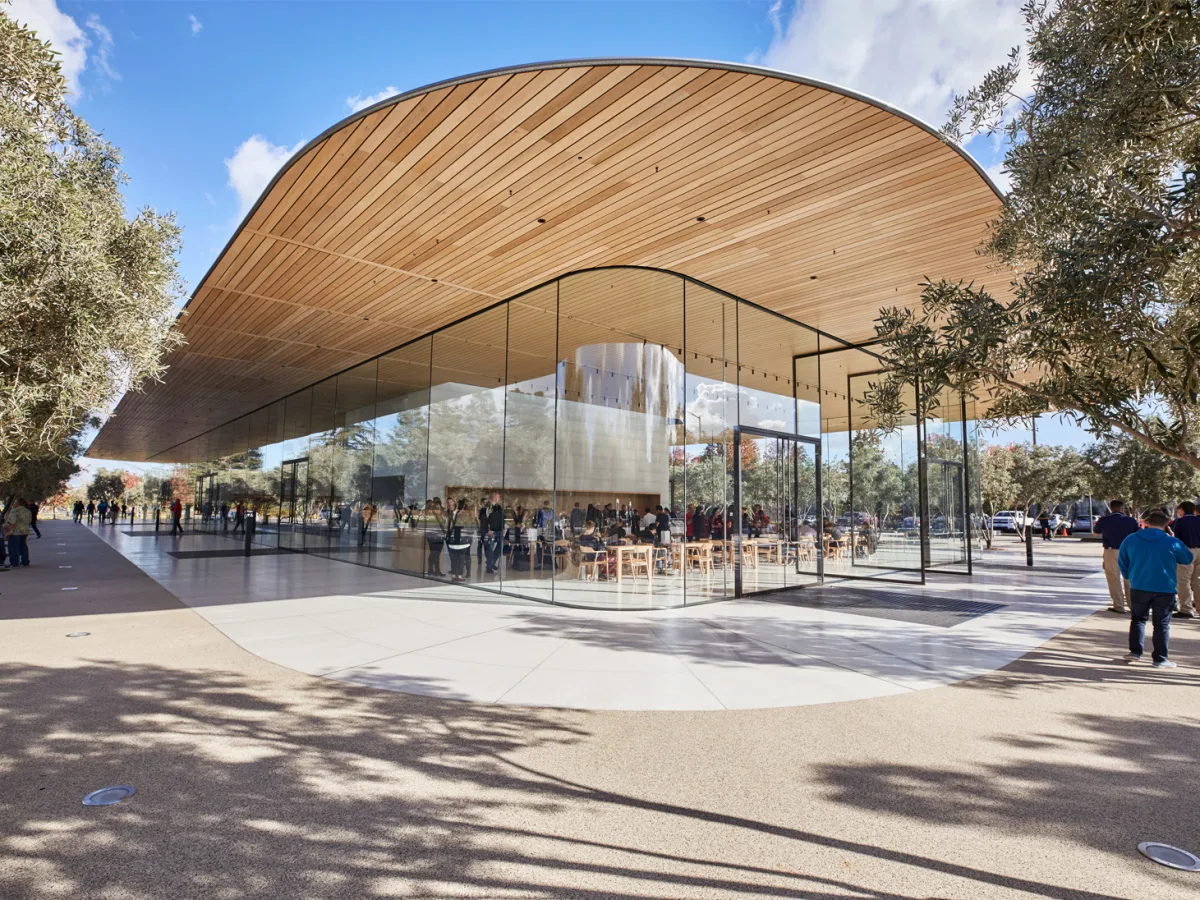 Apple Park 访客中心的木饰屋顶，悬浮于玻璃幕墙与橄榄树之上